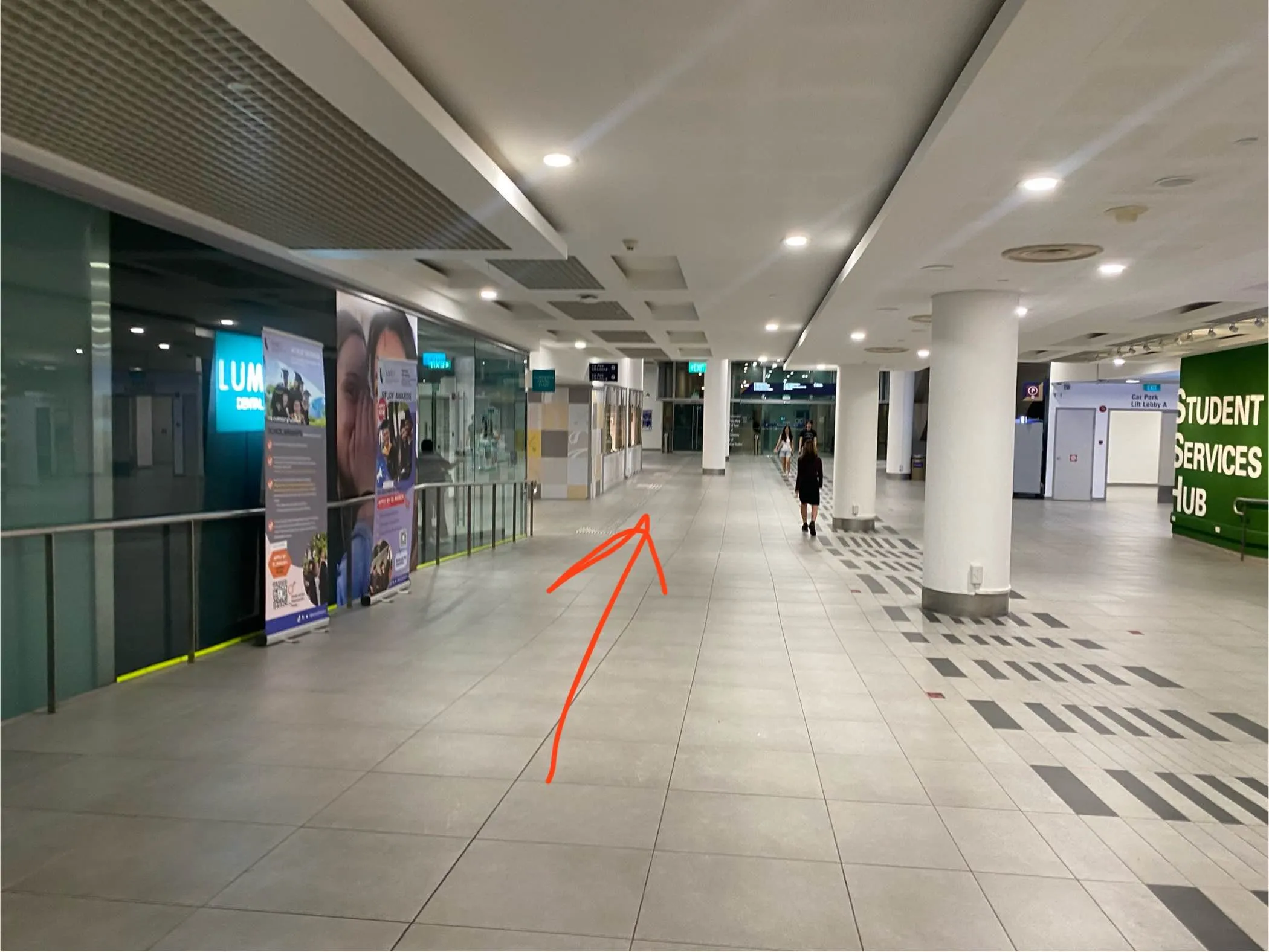 Walkway in SMU flanked by some shops on the left and the Student Services Hub on the right.